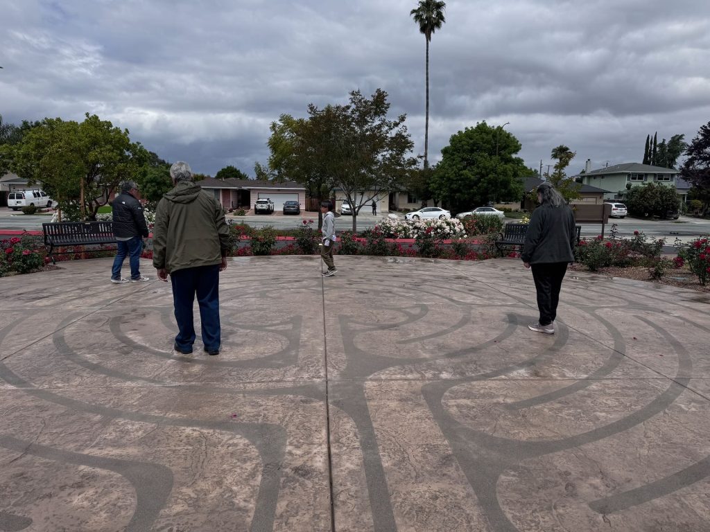 People walking the outdoor prayer labyrinth at Santa Teresa Church in San Jose during quiet reflection